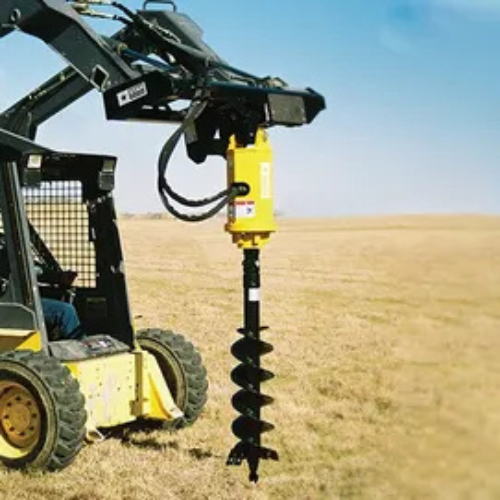 A yellow skid steer loader with an attached auger is in a vast dry field. The sky is clear, conveying a sense of work and functionality in a rural setting.